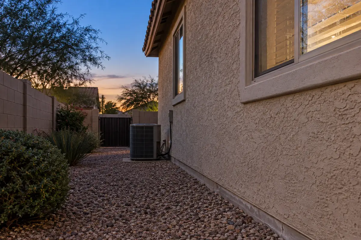 Gravel side yard beside a stucco house at dusk, bed bug treatment in Menifee, CA